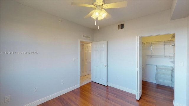 9021 SW 94th St Unit 604, Miami, FL 33176 - unfurnished bedroom featuring a walk in closet, wood finished floors, a closet, and a ceiling fan
