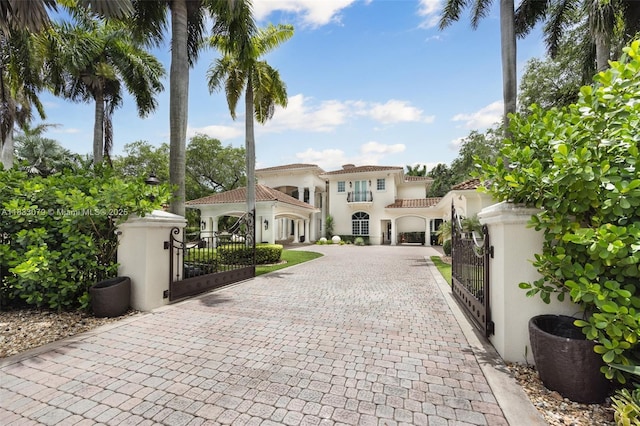 7245 SW 104th St, Pinecrest, FL 33156 - mediterranean / spanish house with a gate, curved driveway, and stucco siding