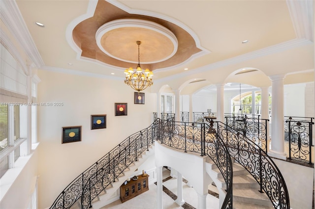 7245 SW 104th St, Pinecrest, FL 33156 - stairway featuring a chandelier, decorative columns, a tray ceiling, crown molding, and arched walkways