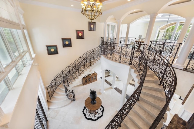 7245 SW 104th St, Pinecrest, FL 33156 - stairway featuring decorative columns, healthy amount of natural light, a chandelier, ornamental molding, and arched walkways