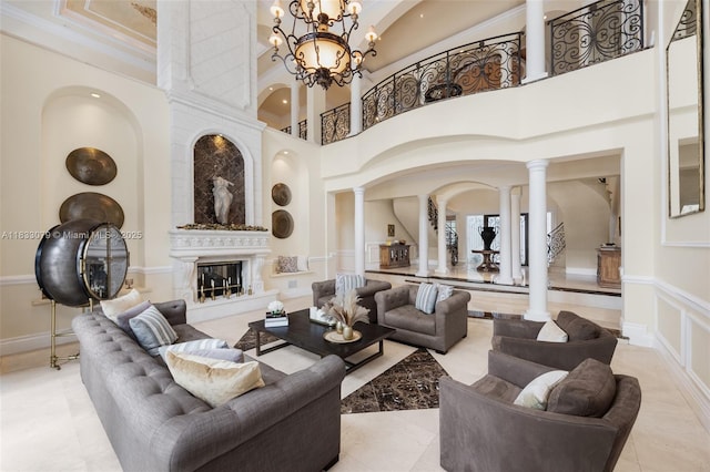 7245 SW 104th St, Pinecrest, FL 33156 - living area with ornate columns, arched walkways, a high ceiling, a fireplace, and a chandelier