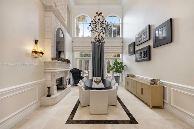 7245 SW 104th St, Pinecrest, FL 33156 - dining area featuring a chandelier, a fireplace with raised hearth, ornamental molding, inlaid floor details, and a wainscoted wall