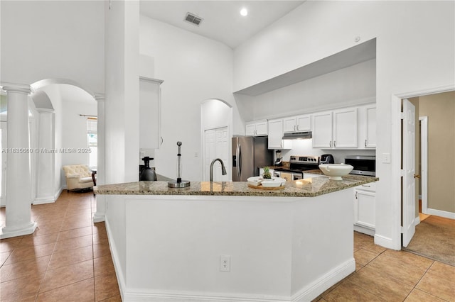 334 Colony St, Kissimmee, FL 34758 - kitchen with appliances with stainless steel finishes, ornate columns, a high ceiling, arched walkways, and light tile patterned flooring
