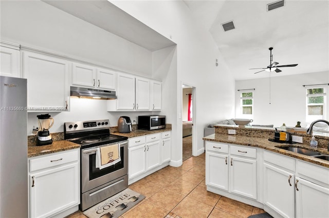 334 Colony St, Kissimmee, FL 34758 - kitchen featuring stainless steel appliances, under cabinet range hood, white cabinets, and high vaulted ceiling