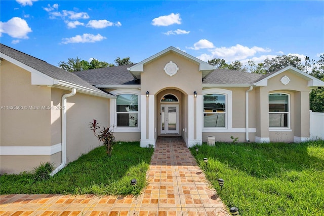 334 Colony St, Kissimmee, FL 34758 - view of front of house featuring stucco siding, french doors, roof with shingles, and a front yard