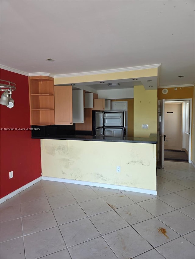 400 Kings Point Dr Unit 401, Sunny Isles Beach, FL 33160 - kitchen with open shelves, ornamental molding, freestanding refrigerator, light tile patterned floors, and dark countertops
