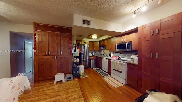 15 Laredo Pl Unit 2-7, Davie, FL 33324 - kitchen featuring appliances with stainless steel finishes, light wood finished floors, a textured ceiling, and light countertops