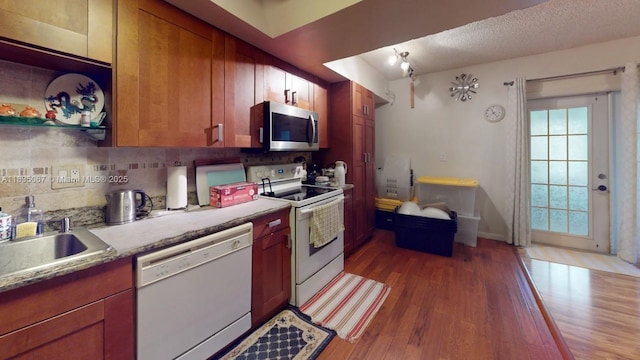 15 Laredo Pl Unit 2-7, Davie, FL 33324 - kitchen with white appliances, dark wood-type flooring, tasteful backsplash, light countertops, and brown cabinetry