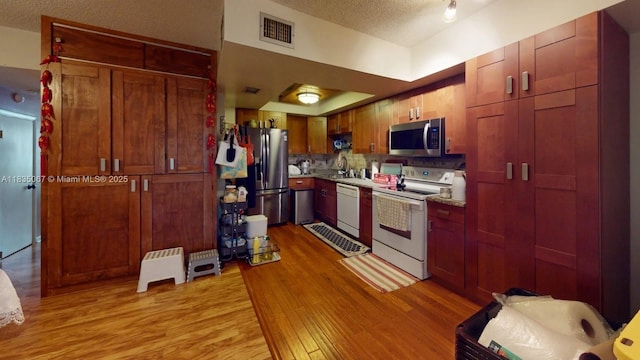 15 Laredo Pl Unit 2-7, Davie, FL 33324 - kitchen featuring appliances with stainless steel finishes, a textured ceiling, light wood finished floors, and light countertops