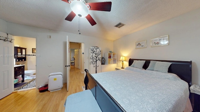15 Laredo Pl Unit 2-7, Davie, FL 33324 - bedroom featuring light wood-type flooring, a textured ceiling, connected bathroom, and ceiling fan