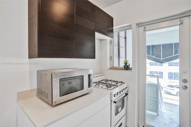 1616 Euclid Ave Unit 4, Miami Beach, FL 33139 - kitchen featuring stainless steel microwave, white range with gas stovetop, and light countertops