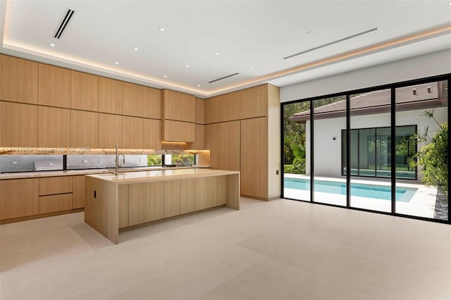6445 SW 102nd Ave, Miami, FL 33173 - kitchen with modern cabinets, light brown cabinets, light countertops, and a kitchen island with sink