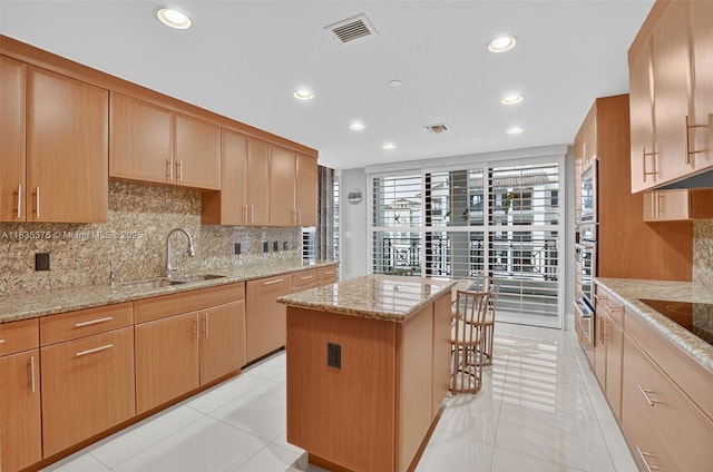 200 E Palmetto Park Rd Unit 714, Boca Raton, FL 33432 - kitchen featuring tasteful backsplash, a center island, recessed lighting, light stone counters, and appliances with stainless steel finishes