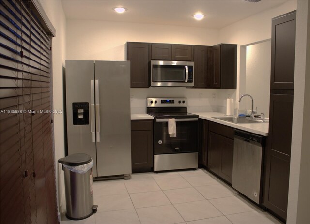 475 NE 5th Ln, Florida City, FL 33034 - kitchen with stainless steel appliances, light countertops, dark brown cabinetry, light tile patterned floors, and recessed lighting