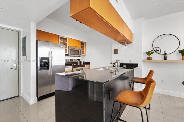 1750 N Bayshore Dr Unit 1611, Miami, FL 33132 - kitchen with appliances with stainless steel finishes, a peninsula, light tile patterned flooring, brown cabinetry, and glass insert cabinets