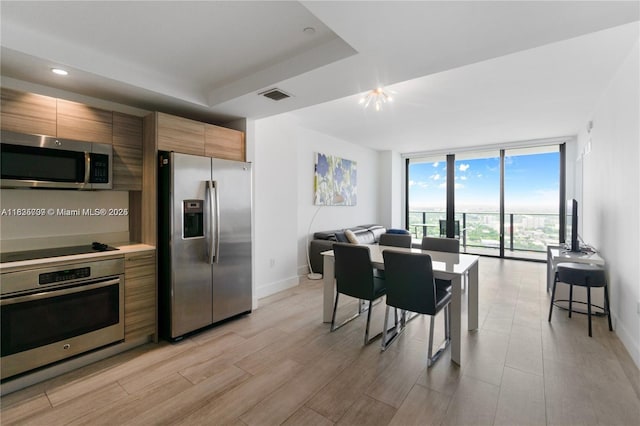 121 NE 34th St Unit 3012, Miami, FL 33137 - kitchen featuring appliances with stainless steel finishes, floor to ceiling windows, modern cabinets, light wood finished floors, and open floor plan
