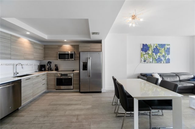 121 NE 34th St Unit 3012, Miami, FL 33137 - kitchen with stainless steel appliances, modern cabinets, a tray ceiling, light countertops, and open floor plan
