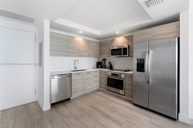 121 NE 34th St Unit 3012, Miami, FL 33137 - kitchen featuring appliances with stainless steel finishes, a raised ceiling, modern cabinets, light countertops, and recessed lighting