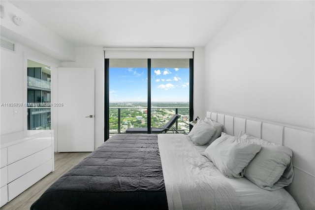 121 NE 34th St Unit 3012, Miami, FL 33137 - bedroom featuring access to outside, wood finished floors, and expansive windows