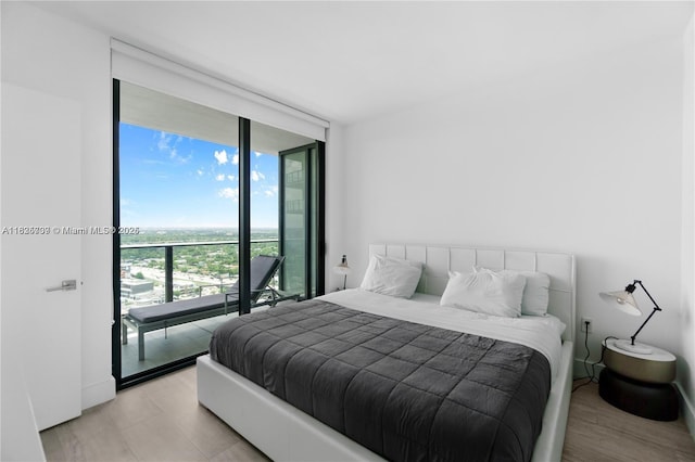 121 NE 34th St Unit 3012, Miami, FL 33137 - bedroom featuring a wall of windows, access to exterior, and light wood-type flooring