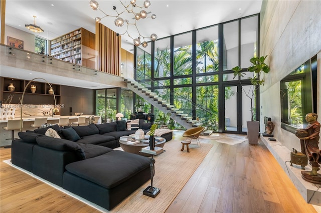 3910 Battersea Rd, Miami, FL 33133 - living room with a towering ceiling, hardwood / wood-style flooring, stairway, and a chandelier