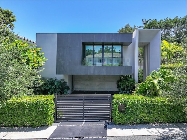 3910 Battersea Rd, Miami, FL 33133 - modern home with a fenced front yard, a gate, and stucco siding