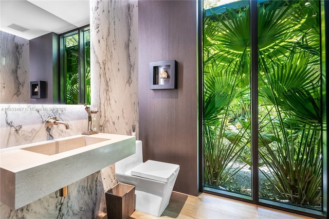 3910 Battersea Rd, Miami, FL 33133 - half bathroom with expansive windows, healthy amount of natural light, and wood finished floors