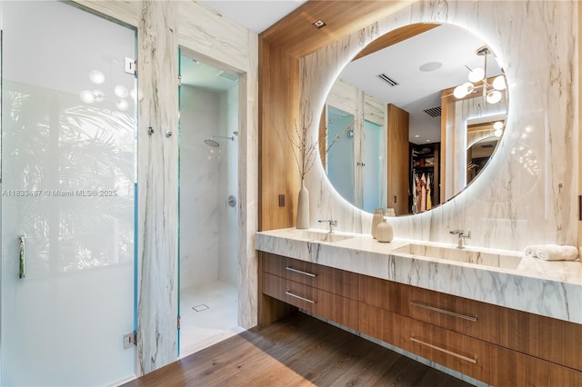 3910 Battersea Rd, Miami, FL 33133 - full bathroom with a spacious closet, double vanity, a marble finish shower, and wood finished floors