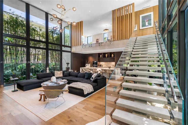 3910 Battersea Rd, Miami, FL 33133 - living area with a wall of windows, a towering ceiling, stairs, wood finished floors, and a chandelier