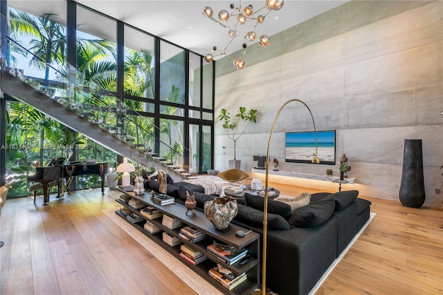 3910 Battersea Rd, Miami, FL 33133 - living room featuring a towering ceiling, expansive windows, wood-type flooring, a chandelier, and stairway