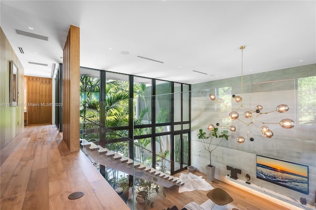 3910 Battersea Rd, Miami, FL 33133 - corridor featuring wood finished floors, floor to ceiling windows, plenty of natural light, and a chandelier
