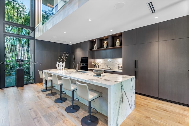 3910 Battersea Rd, Miami, FL 33133 - kitchen featuring open shelves, modern cabinets, light wood finished floors, and backsplash
