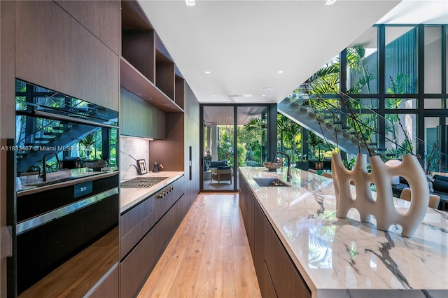 3910 Battersea Rd, Miami, FL 33133 - kitchen with modern cabinets, open shelves, light stone counters, light wood-style flooring, and recessed lighting