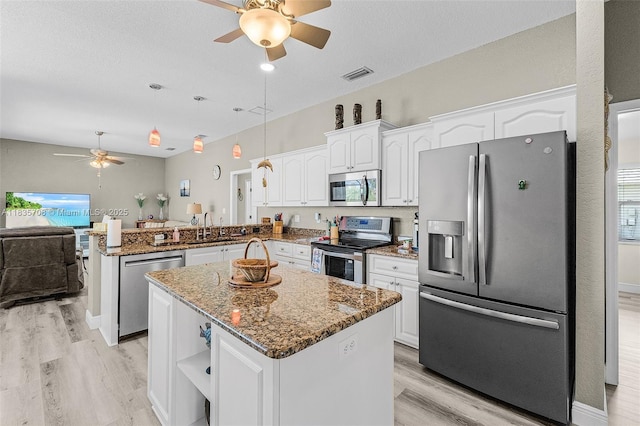7130 Scarlet Sage Ct, Punta Gorda, FL 33955 - kitchen featuring stainless steel appliances, a ceiling fan, a peninsula, light wood finished floors, and white cabinetry