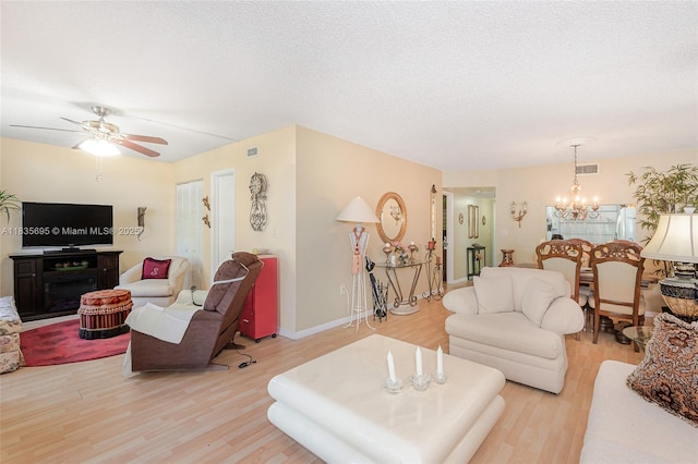 901 Colony Point Cir Unit 107, Pembroke Pines, FL 33026 - living room featuring light wood-style flooring, a chandelier, a ceiling fan, and a textured ceiling