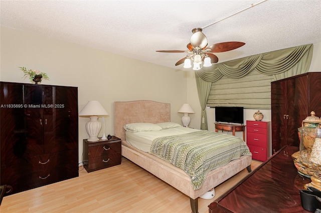 901 Colony Point Cir Unit 107, Pembroke Pines, FL 33026 - bedroom with wood finished floors, a textured ceiling, and ceiling fan