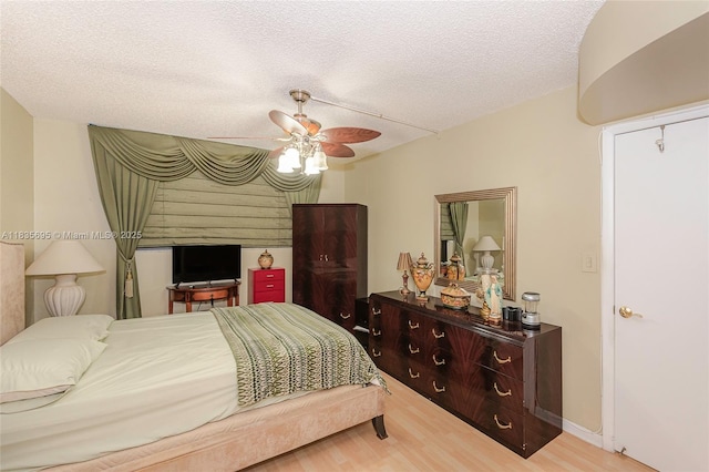 901 Colony Point Cir Unit 107, Pembroke Pines, FL 33026 - bedroom featuring light wood finished floors, a ceiling fan, and a textured ceiling
