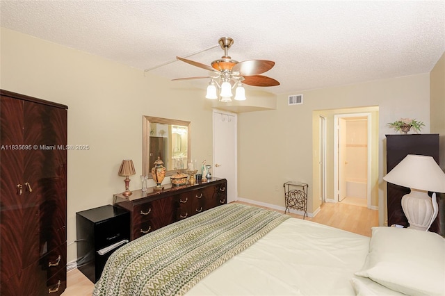 901 Colony Point Cir Unit 107, Pembroke Pines, FL 33026 - bedroom featuring a textured ceiling, a ceiling fan, wood finished floors, and ensuite bathroom