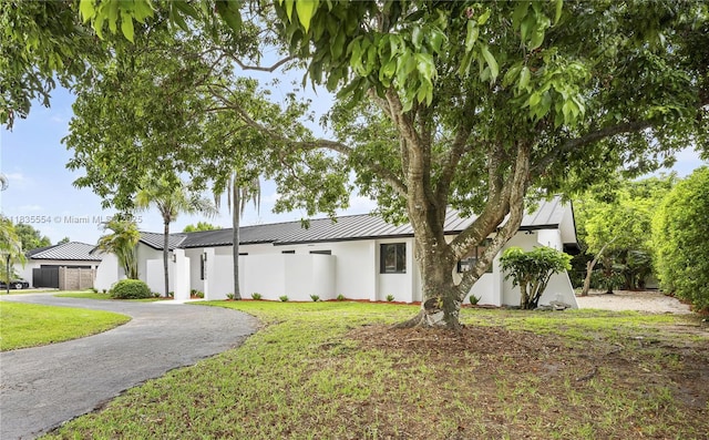 12505 SW 99th Ave, Miami, FL 33176 - view of front of property featuring a standing seam roof, a metal roof, a front lawn, and stucco siding