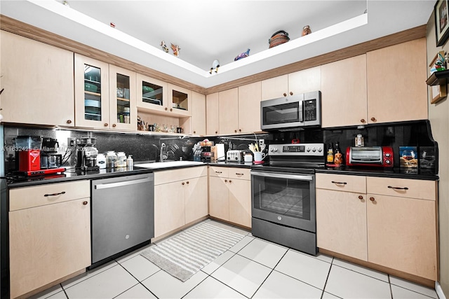 9341 E Bay Harbor Dr Unit 3D, Bay Harbor Islands, FL 33154 - kitchen with stainless steel appliances, tasteful backsplash, a raised ceiling, and dark countertops