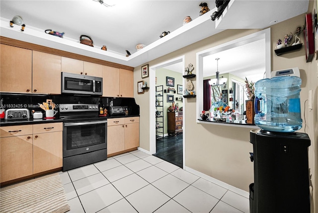 9341 E Bay Harbor Dr Unit 3D, Bay Harbor Islands, FL 33154 - kitchen with stainless steel microwave, electric range oven, dark countertops, light brown cabinets, and light tile patterned floors