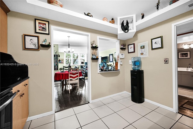 9341 E Bay Harbor Dr Unit 3D, Bay Harbor Islands, FL 33154 - kitchen with a chandelier, stove, and light tile patterned flooring