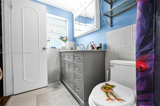 9341 E Bay Harbor Dr Unit 3D, Bay Harbor Islands, FL 33154 - bathroom featuring tile walls, vanity, tile patterned flooring, and a wainscoted wall