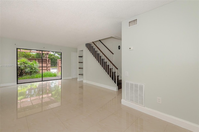 6455SW SW 116th Pl Unit C, Miami, FL 33173 - unfurnished room featuring a textured ceiling, stairway, and light tile patterned floors