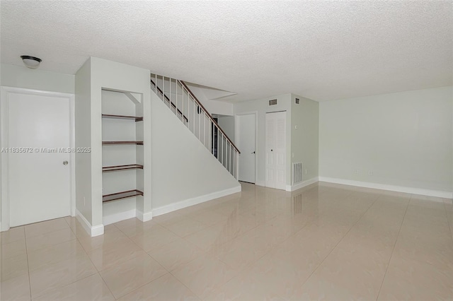 6455SW SW 116th Pl Unit C, Miami, FL 33173 - unfurnished living room featuring a textured ceiling, stairway, and light tile patterned floors