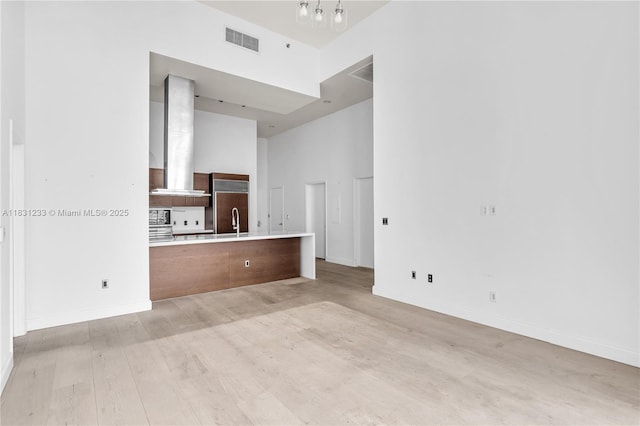 495 SE Brickell Ave Unit 1511, Miami, FL 33131 - unfurnished living room with a towering ceiling and light wood-style floors