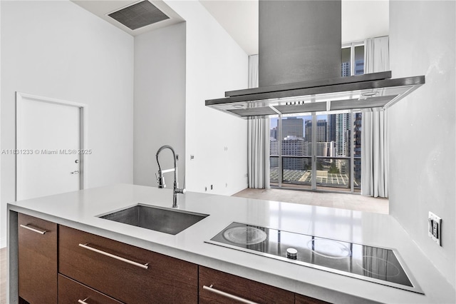 495 SE Brickell Ave Unit 1511, Miami, FL 33131 - kitchen featuring wall chimney range hood, black electric cooktop, light countertops, dark brown cabinetry, and modern cabinets