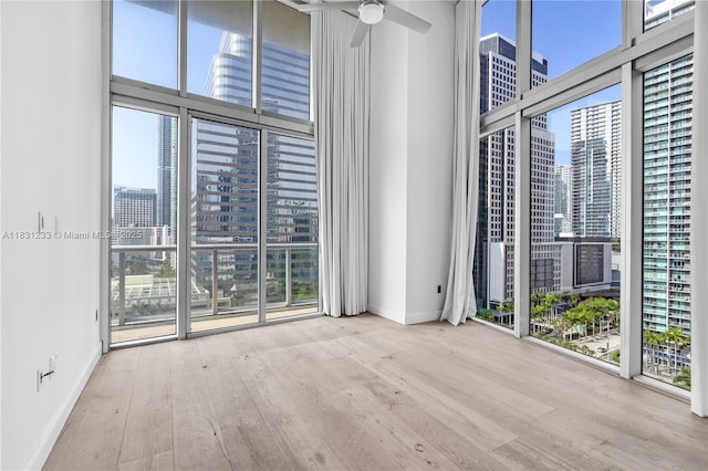 495 SE Brickell Ave Unit 1511, Miami, FL 33131 - spare room with a view of city, a high ceiling, wood finished floors, a wall of windows, and a ceiling fan
