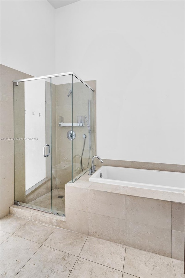 495 SE Brickell Ave Unit 1511, Miami, FL 33131 - bathroom with a bath, a stall shower, and tile patterned floors