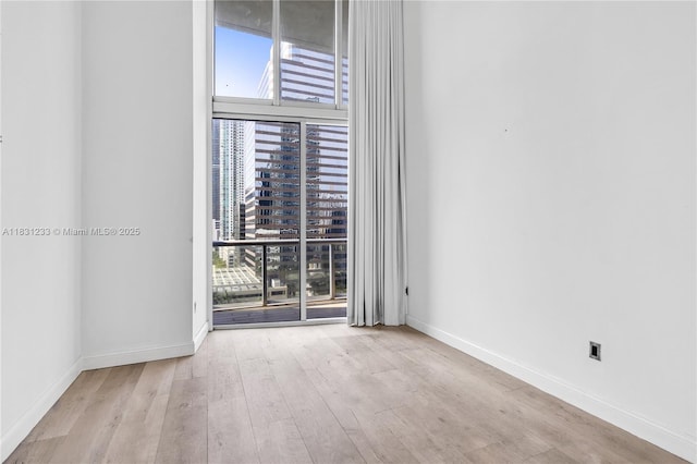 495 SE Brickell Ave Unit 1511, Miami, FL 33131 - empty room featuring wood finished floors, a city view, and floor to ceiling windows